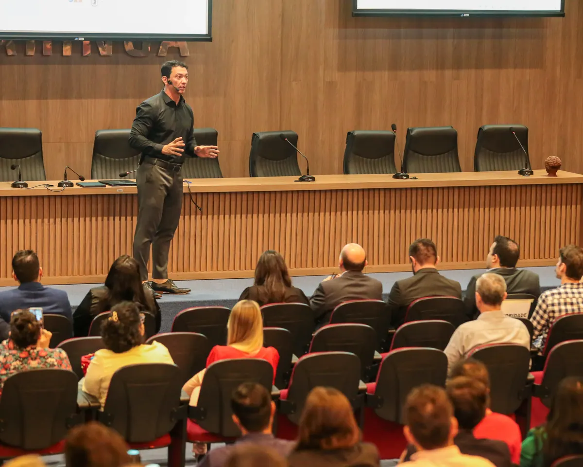 Luciano Tokikawa palestrando para uma plateia em auditório